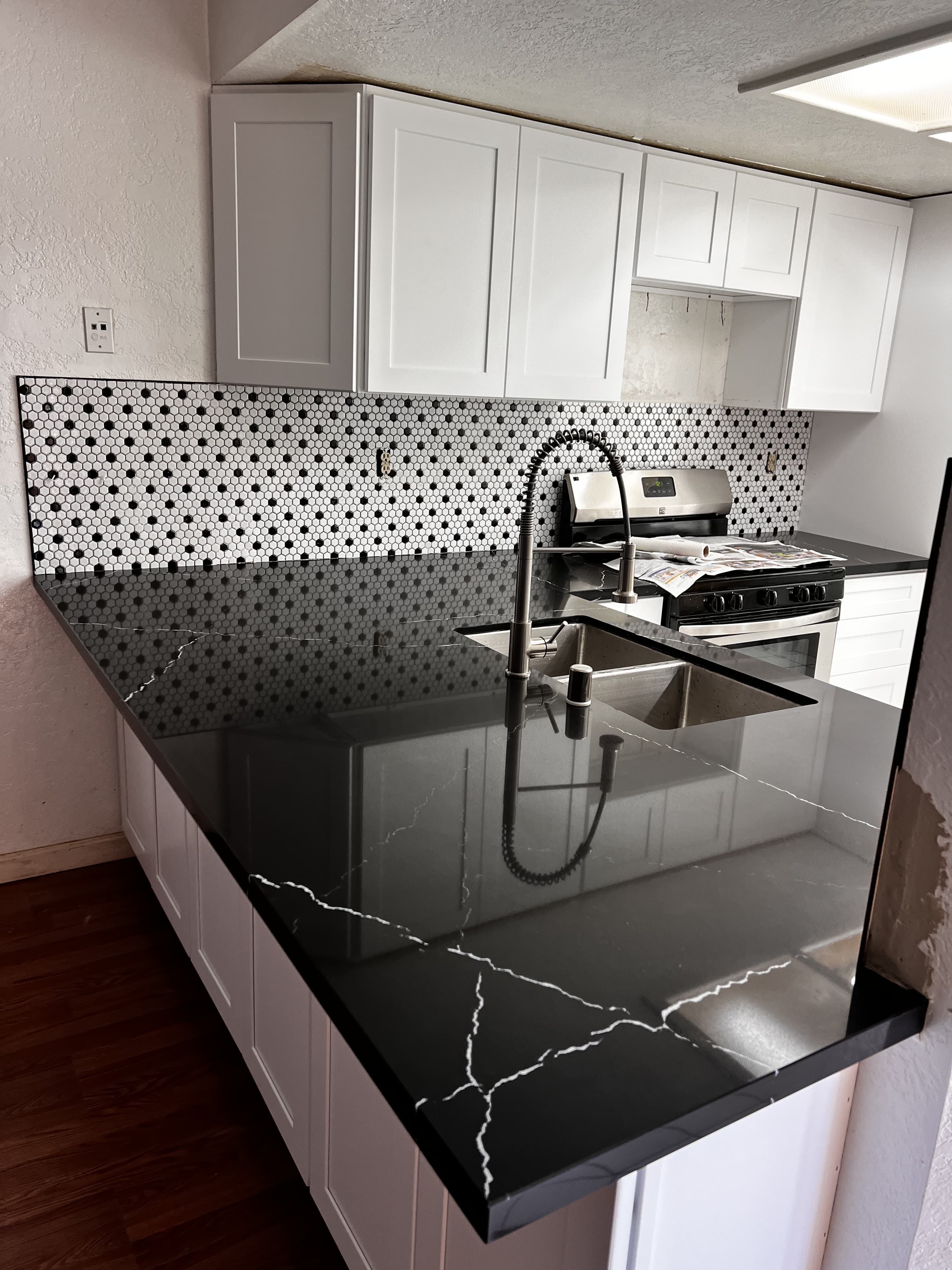 Kitchen remodel with black marble countertop and penny tile backsplash